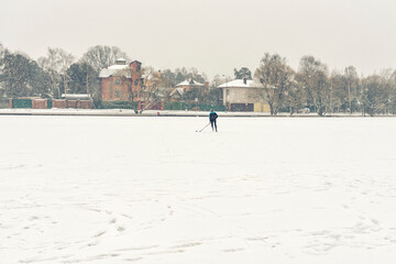 hockey player trains alone on a frozen lake in heavy snow. people are not visible due to snow blur