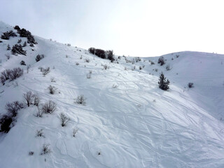Fototapeta na wymiar Mountain in Chimgan covered with snow with ski tracks