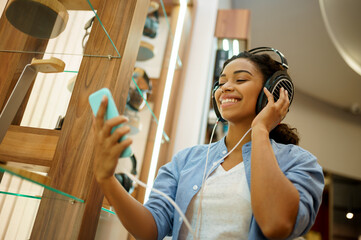 Woman listening to music in headphones store