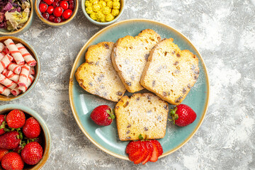 top view delicious cake slices with fruits and candies on light background cakes sweet pie