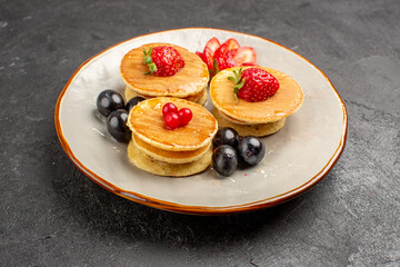 front view yummy pancakes little formed with fruits on dark background fruit cake pie
