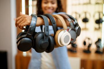 Woman shows headphones collection in audio store