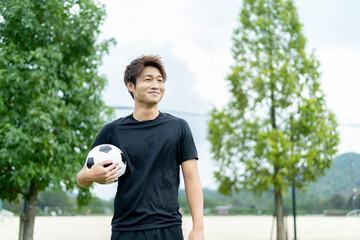 公園でサッカーをする若い男性