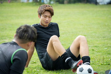 公園でサッカーをする若い男性