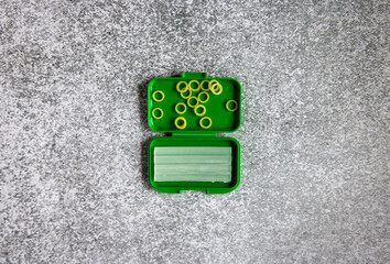 orthodontic bands and wax in a green box on a gray background