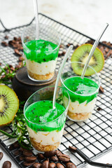 Dessert: cream, nuts and kiwi jam in plastic cups. Top view. Sweet bar.