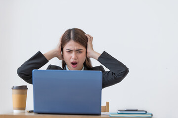 Shocked Asian businesswoman working on a laptop at her office, Negative emotions on a face, Stress in business work