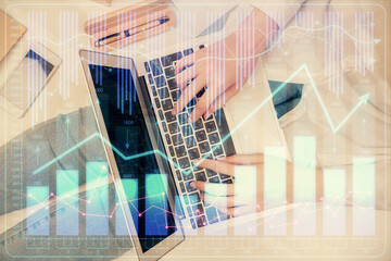 Double exposure of woman hands working on computer and forex graph hologram drawing. Top View....