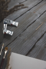 
paper, paints and brushes on a wooden background whit dried flowers 