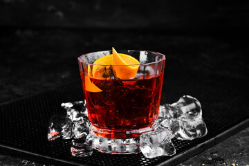 Traditional Negroni cocktail on black stone background. Menu bar. Alcohol.