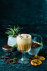 Coffee with cream and rum with coffee beans. On a black background. Top view.