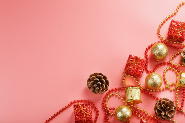Christmas composition of decorations and Christmas toys on a pink background.