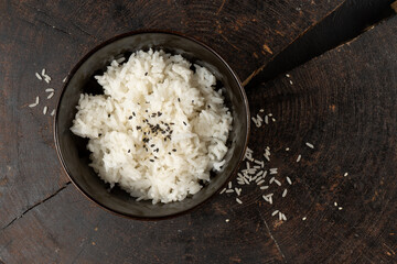Sesame steamed rice in a deep ceramic bowl with wooden chopsticks. A classic hot oriental Asian dish.