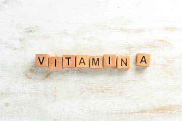 The inscription "VITAMIN A" is laid out of wooden cubes. Top view.