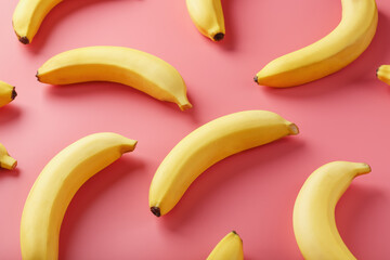 Geometric pattern of bananas on a pink background. The view from the top.