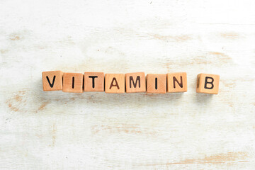 The inscription "VITAMIN B" is laid out of wooden cubes. Top view.