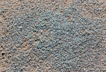 The texture of broken glass on sand close-up.
