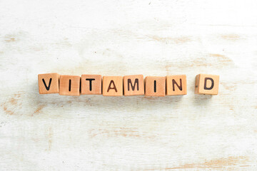 The inscription "VITAMIN D" is laid out of wooden cubes. Top view.