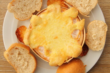 an oven-baked camembert with bread rolls