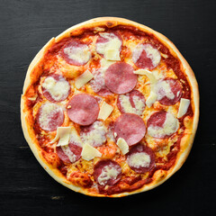 Traditional pizza with salami sausage and mozzarella. Top view. free space for your text. Rustic style.