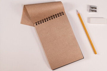 brown notepad spiral pencil on white background