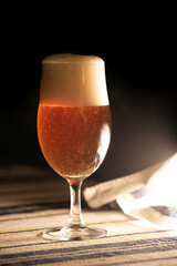 A glass of delicious craft beer on an authentic table cloth.