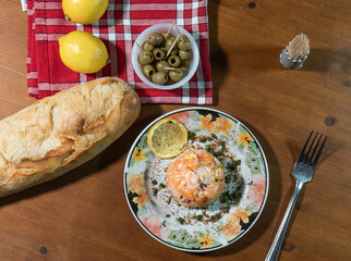 Delicious salmon tartare with chives and lemon on a wooden table