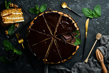 Delicious chocolate cake on a black stone plate. Top view. Rustic style.