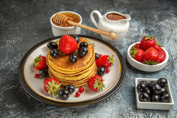 front view yummy pancakes with honey and fruits on light background sweet fruit cake