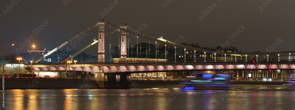 Wall mural Long exposure of Moskva river and Krymsky bridge at winter bright night. City is full of lights reflections and right lines. Сoronavirus pandemic. Blurred silhouettes of tourist river trams