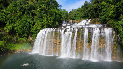Cascade of Tinuy-an Falls in green forest, aerial drone. Waterfall in the tropical mountain jungle. Philippines, Mindanao.