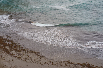 Photography of the Atlantic Ocean surf  in the Bay of Biscay. Waves running onto the sandy shore in summer day. Natural fresh background for poster, banner, postcard, greeting card, touristic guide