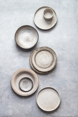 handmade ceramics, empty craft ceramic plates and bowls on light background, top view