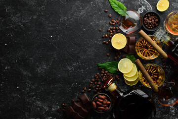Brandy in glasses on a black stone table. Top view. Free space for your text.