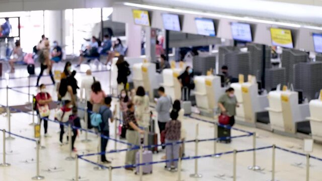 Blurred And Unrecognizable Asian People Waiting To Check In At The Airport. Everyone Wearing Disposal Face Mask For Protect Coronavirus. Airport Open After Covid-19 Epidemic