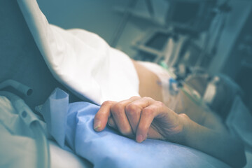 Elderly patient with catheterized hand on the mechanical ventilation in intensive care