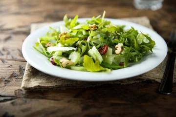 Fototapeten Healthy arugula salad with celery and walnut © marysckin