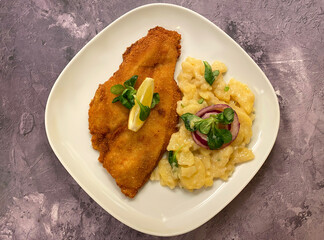 Classic breaded plaice fish fillets, coated in flour, egg, breadcrumbs and fried in oil to golden. Served with potato salad.