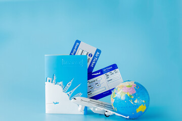 Flight tickets with passports, model of airplane and globe on blue background. Summer or vacation concept. Copy space