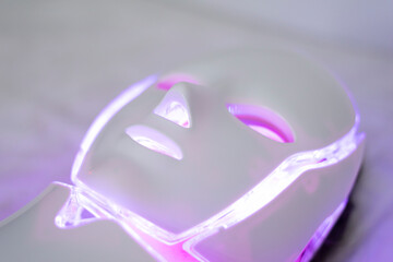 Woman With Led Light Therapy Facial Beauty Mask Photon Therapy. Woman receiving face light therapy in LED mask.