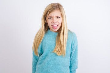 Body language. Disgusted stressed out Cute Caucasian kid girl wearing blue knitted sweater against...