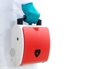 Aed rescue equipment Or a red heart defibrillator In the doctor's hand White background - obrazy, fototapety, plakaty