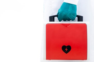 Aed rescue equipment Or a red heart defibrillator In the doctor's hand White background