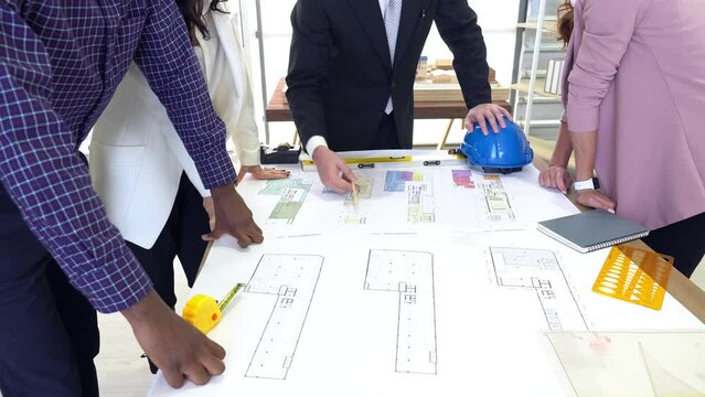 multiethnic architecture and engineer team including man, woman, black and caucasian  people discussing about building project in office