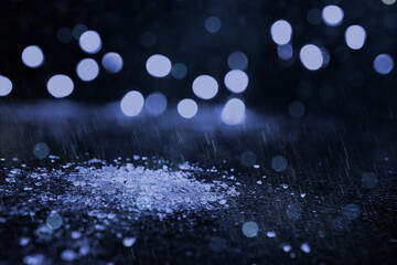 Glasscherben im Regen am Boden - Lichtreflektionen im Hintergrund - blau