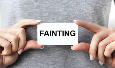 In front of him holds a girl's card with the text FAINTING.