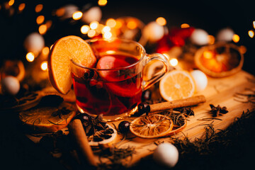 Fototapeta Christmas mulled wine, Drink with dried fruits and berries, Winter hot tea in a glass and spices on a wooden background. obraz