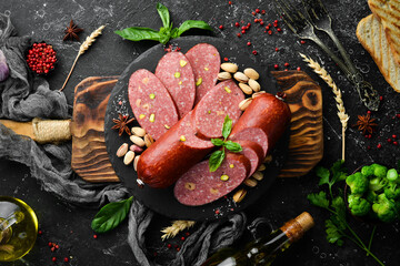 Salami with nuts: pistachios and hazelnuts. Top view. Rustic style.