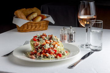 Fresh salad with wine, bread basket and cheese. on a white table