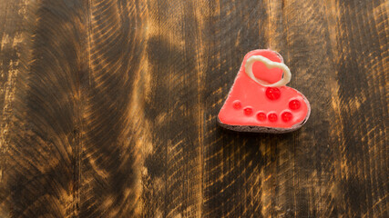 Valentine's day concept. Red heart on a wooden background. Sweet gift. A symbol of love, happiness and devotion. View from above.